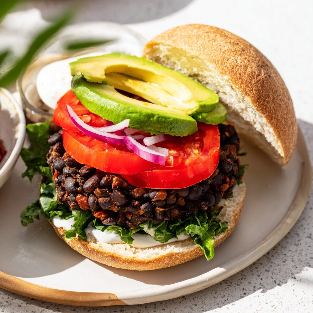 A juicy, vegetarian Zesty Weeknight Black Bean Burger, topped with creamy avocado slices.