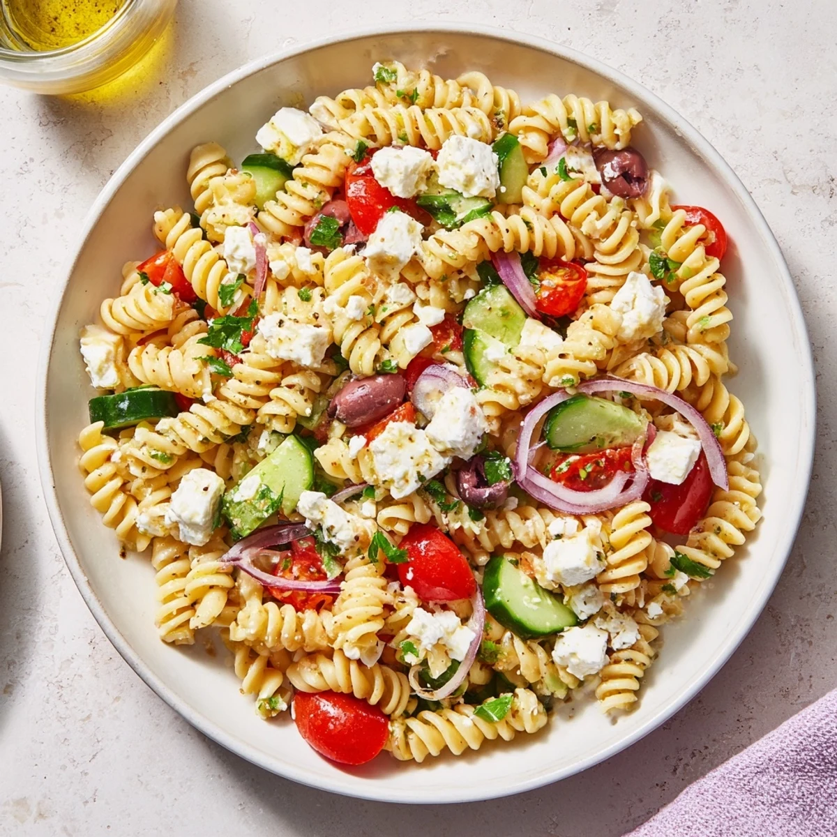 A colorful bowl of Mediterranean Olive Oil and Feta Pasta Salad, ready for a taste of the Mediterranean.