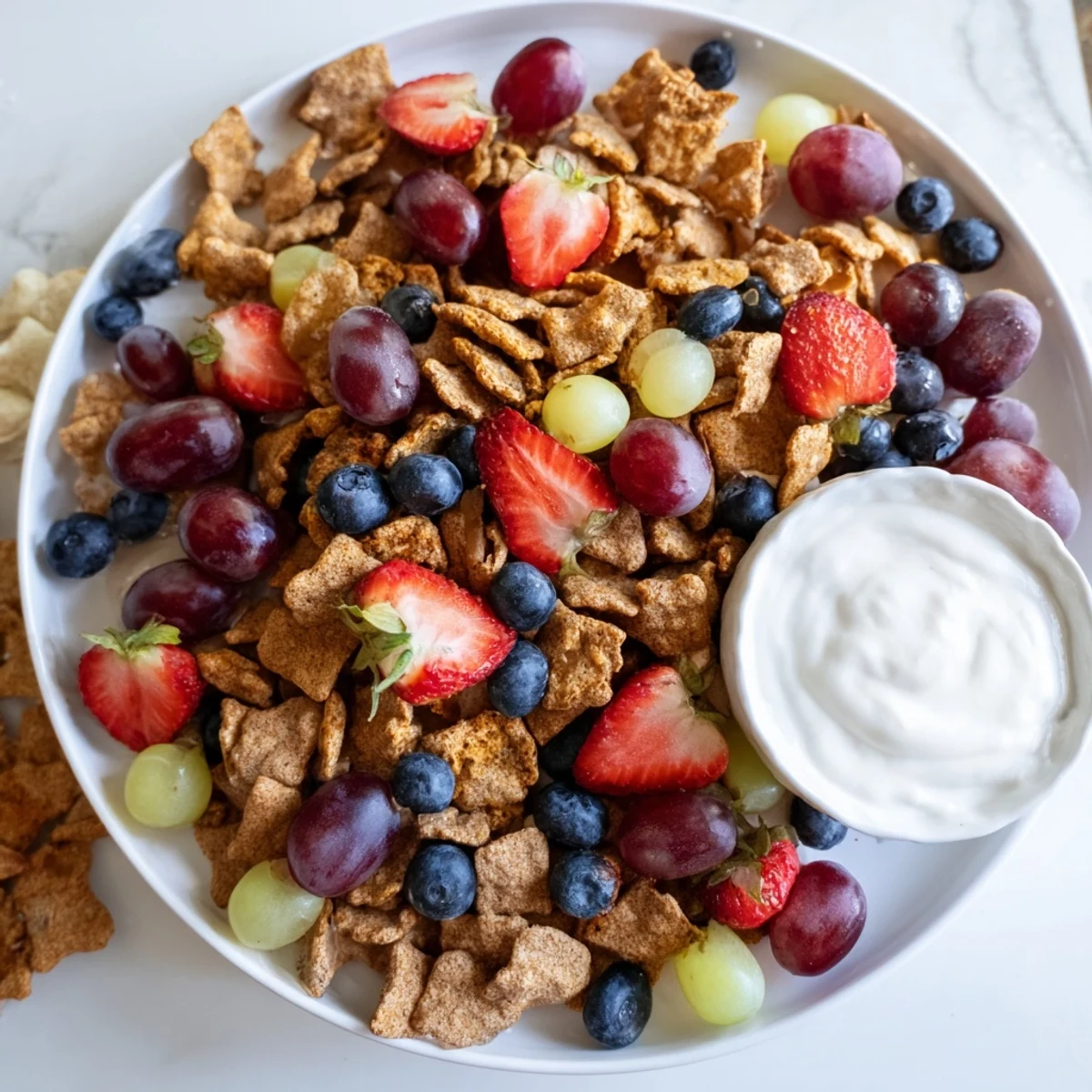 Vibrant pile of rainbow Goldfish crackers with colorful fruit, ready for snacking, perfect kid's treat.