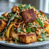 Vibrant Thai mango salad featuring julienned mango, crunchy vegetables, and golden tofu with rich peanut dressing.  