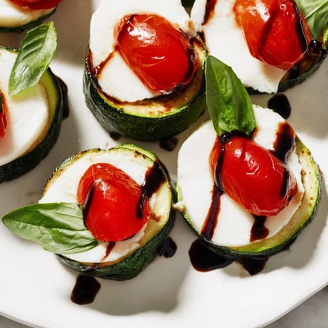 Fresh Zucchini Caprese Bites, perfect appetizer drizzled with balsamic glaze, served with fresh basil.