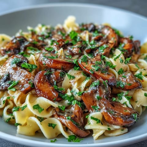 Savory Creamy Mushroom Stroganoff featuring sautéed cremini mushrooms in a rich, velvety miso sauce tossed with wide noodles.