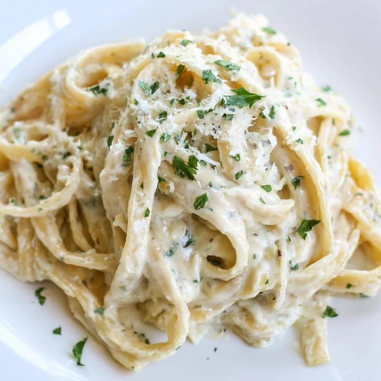 Savory Pasta Alfredo Cottage Hack being served, the cottage cheese sauce clings to each noodle with Parmesan cheese visible.