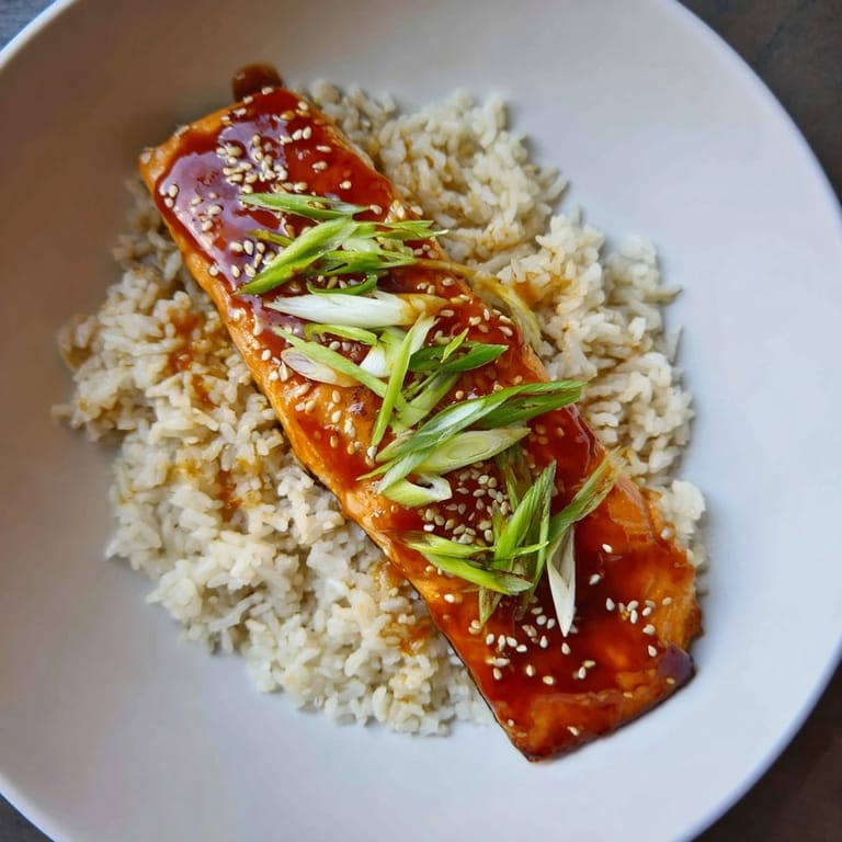Enjoy a delicious plate of sticky orange salmon, a pescatarian delight served warm and flavorful.