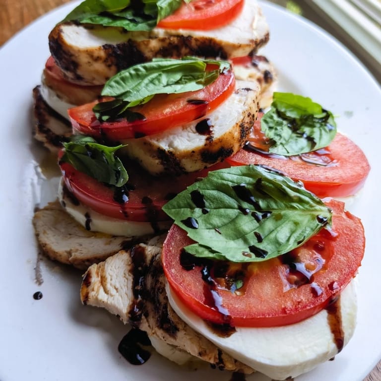 Juicy grilled chicken, fresh basil, and sliced tomatoes create a colorful and appetizing Chicken Caprese Salad, perfect for a light lunch.