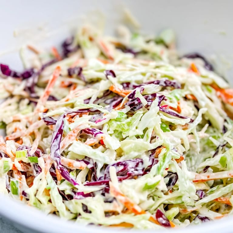 Bright, crunchy Best Cabbage Coleslaw with shredded cabbage and carrots in a creamy dressing, paired alongside grilled chicken.